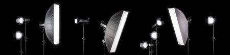 Photography studio flash on a lighting stand isolated on black background with copy space....
