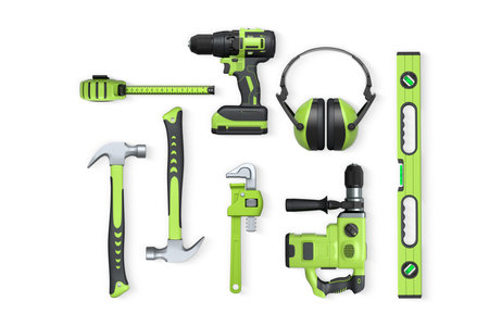 Assorted construction tools including drill, hammer, tape, wrench, and earmuffs isolated on white...