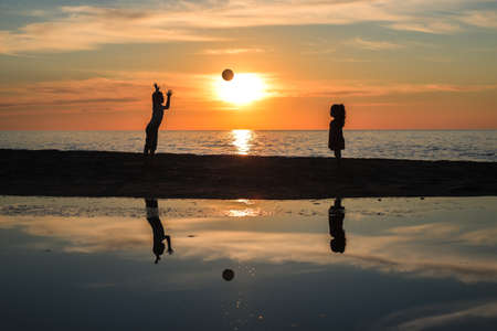 Children playing in sunset with ball, silhouettes, freedom and happiness