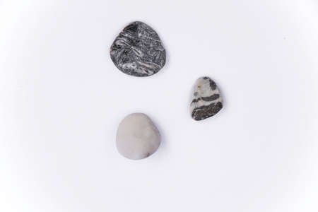 Stones isolated on a white background, Collection of various sea pebble stones on white background. Top view, flat lay, pebble beach isolated on white, Smooth sea rocks, colorful pebbles isolated.の写真素材