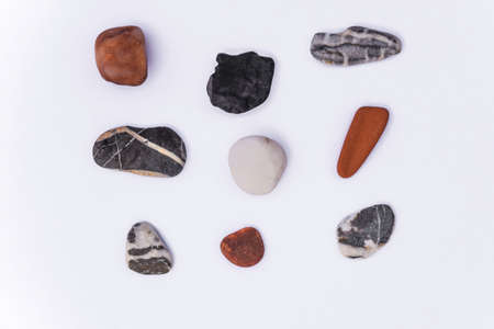 Stones isolated on a white background, Collection of various sea pebble stones on white background. Top view, flat lay, pebble beach isolated on white, Smooth sea rocks, colorful pebbles isolated.の写真素材