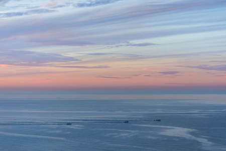 Fishing boats on a fishing trip in the Mediterranean sea with sunset, blue sky and clouds, fishing in the sea, aerial photo of a boat at sea.の写真素材