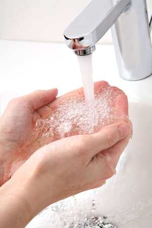 A young woman is washing hands in modern bathroom.