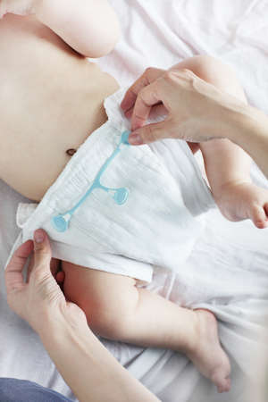 Mother changing babies cloth diaper. の写真素材