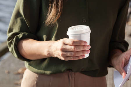 Young woman drinking coffee from disposable cupの写真素材
