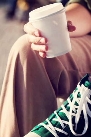 Young woman drinking coffee from disposable cupの写真素材