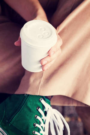 Young woman drinking coffee from am disposable cupの写真素材