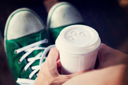 Young woman drinking coffee from am disposable cupの写真素材