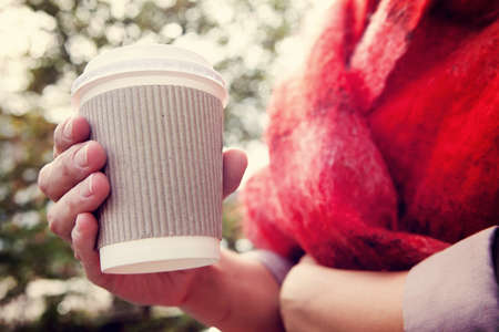 Young woman drinking coffee from disposable cupの写真素材