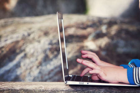 child playing with computer in the park.の写真素材