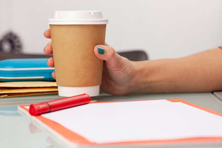 Young woman drinking coffee from disposable cupの写真素材
