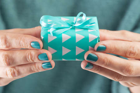 Close-up of female hand holding a present