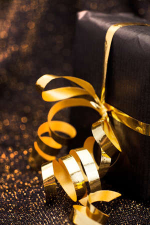 Black gift box on black shiny background.の写真素材