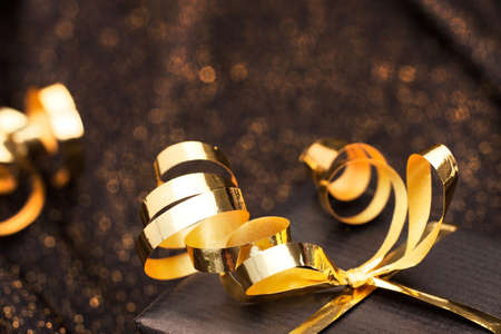 Black gift box on black shiny background.の写真素材