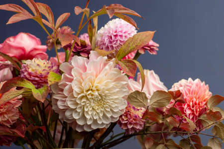 Floral composition of dahlia flowers, roses and autumn leaves.