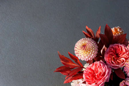 Floral composition of dahlia flowers, roses and autumn leaves.