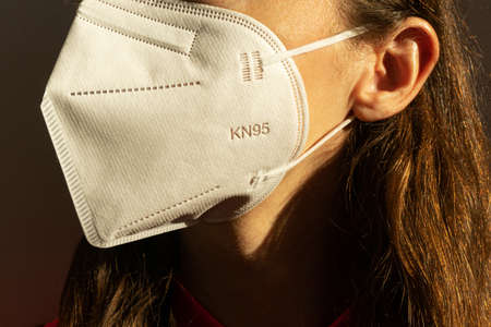 Young woman wearing KN-95 protection medical mask. Prevention of the spread of virus and epidemic, protective mouth filter mask. Diseases, air pollution and coronavirus defense concept.の写真素材
