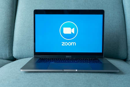 Laptop showing Zoom Cloud Meetings app logo. Work and have meetings from home.のeditorial素材