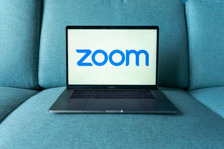 Laptop showing Zoom Cloud Meetings app logo. Work and have meetings from home.のeditorial素材