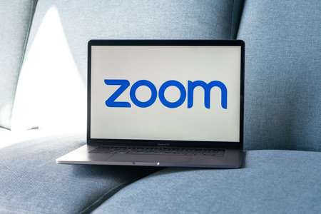 Laptop showing Zoom Cloud Meetings app logo. Work and have meetings from home.のeditorial素材