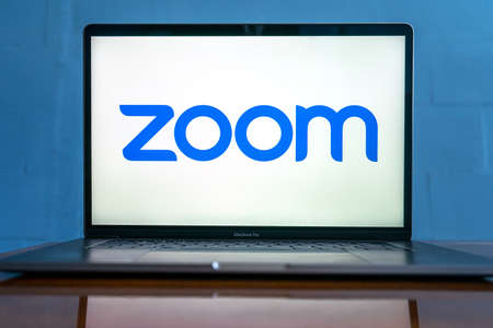 Laptop showing Zoom Cloud Meetings app logo. Work and have meetings from home.のeditorial素材
