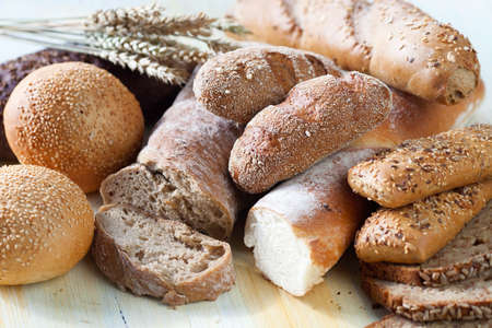 Composition of fresh bread on vintage wooden table, photographed from above