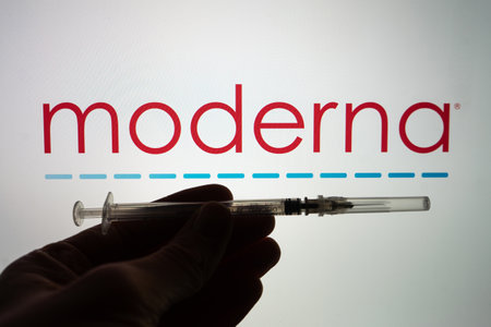 Moderna coronavirus vaccine pharmaceutical corporation. Moderna logo with hand holding vaccine syringe.のeditorial素材
