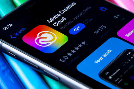 Mobile Adobe creative cloud app on appStore with a colorful plasticine background. Installing creative cloud on the iPhone.のeditorial素材