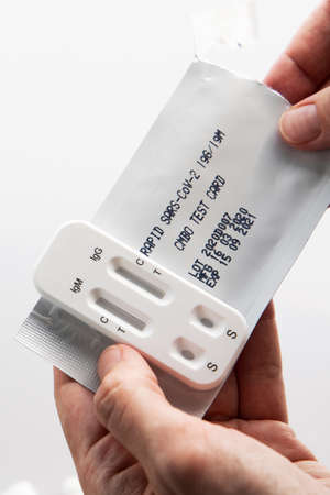 Rapid sars-cov-2 blood test for self testing. Woman holds a kit of fast s test for personal use at...