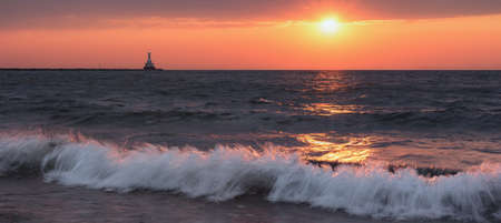 Sunset Beach Panorama with Crashing Waves. Tranquil Lake Superior background with blissful orange sky. Oceans of copy space.の写真素材