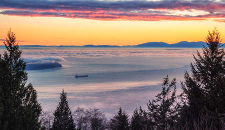 Burrard Inlet Sunset. Scenic view of this British Columbia waterway and the Strait of Georgia with Vancouver Island on the distant horizon. Seascape background with copy space.の写真素材