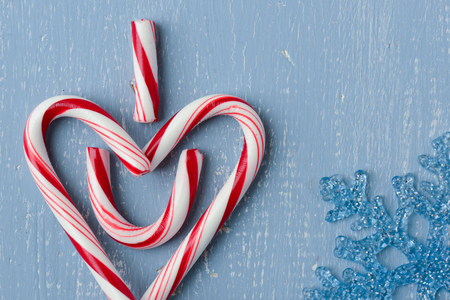 Candy Cane Heart Symbol on Blue Wood with Snowflakeの写真素材