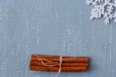 Cinnamon and Snowflake on Blue Wood with Pineconesの写真素材