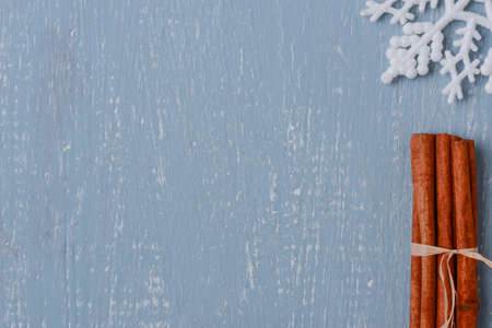 Cinnamon and Snowflake on Blue Wood with Pinecones
