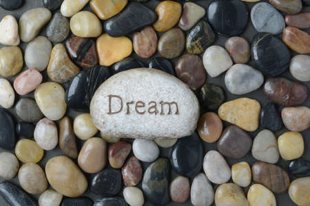 Flush Pebble Stone and River Background with the word Dream on single rockの写真素材
