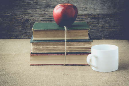 books and apple  with coffee cup on retro background の写真素材