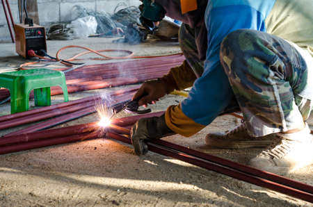 Worker welding the steel part 