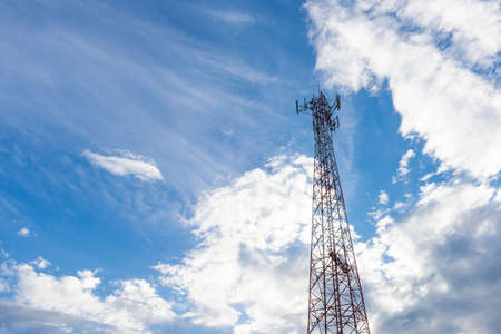 Mobile phone communication antenna tower with the blue sky and clouds