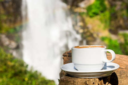 coffee cup with waterfall backgroundの写真素材