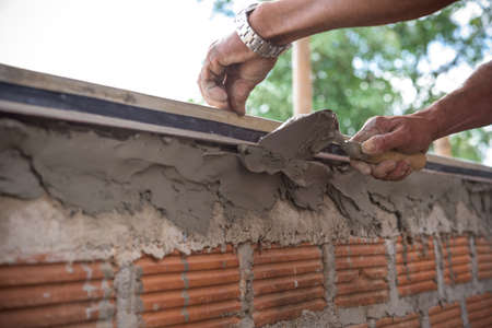 Builder worker plastering  concrete at wall