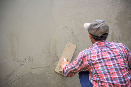 Builder worker plastering  concrete at wallの写真素材