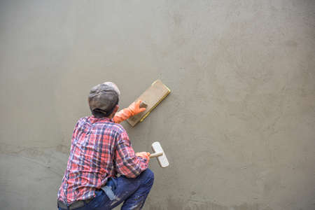 Builder worker plastering  concrete at wallの写真素材