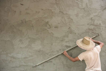 Builder worker plastering  concrete at wall