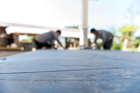 worker putting ceramist tile on the floor. Professional ceramist is laying ceramic tile on the floor (focus tile)の写真素材