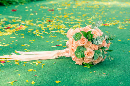 picture of a wedding bouquet , Wedding bouquet of roses lying on green backgroundの写真素材