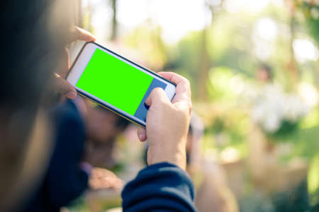 People use smart phone to take photographs in Thai wedding ceremony. (green screen at smart phones)の写真素材