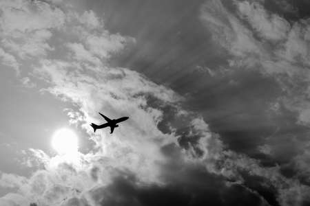 black and white of airplane with sun and ray light