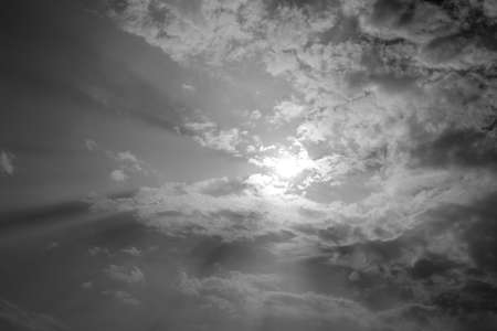 black and white of sun rays are striking through the clouds