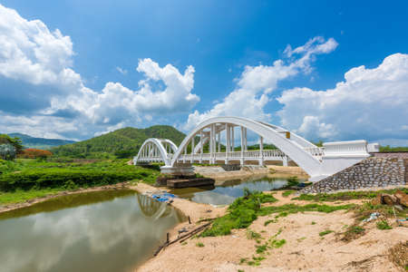 Old white railway bridge constructed against blue sky at Lamphun, Thailand.の写真素材