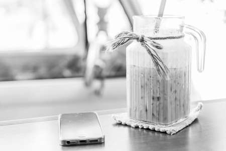 black and white of Smart phones and iced coffee on the table.
